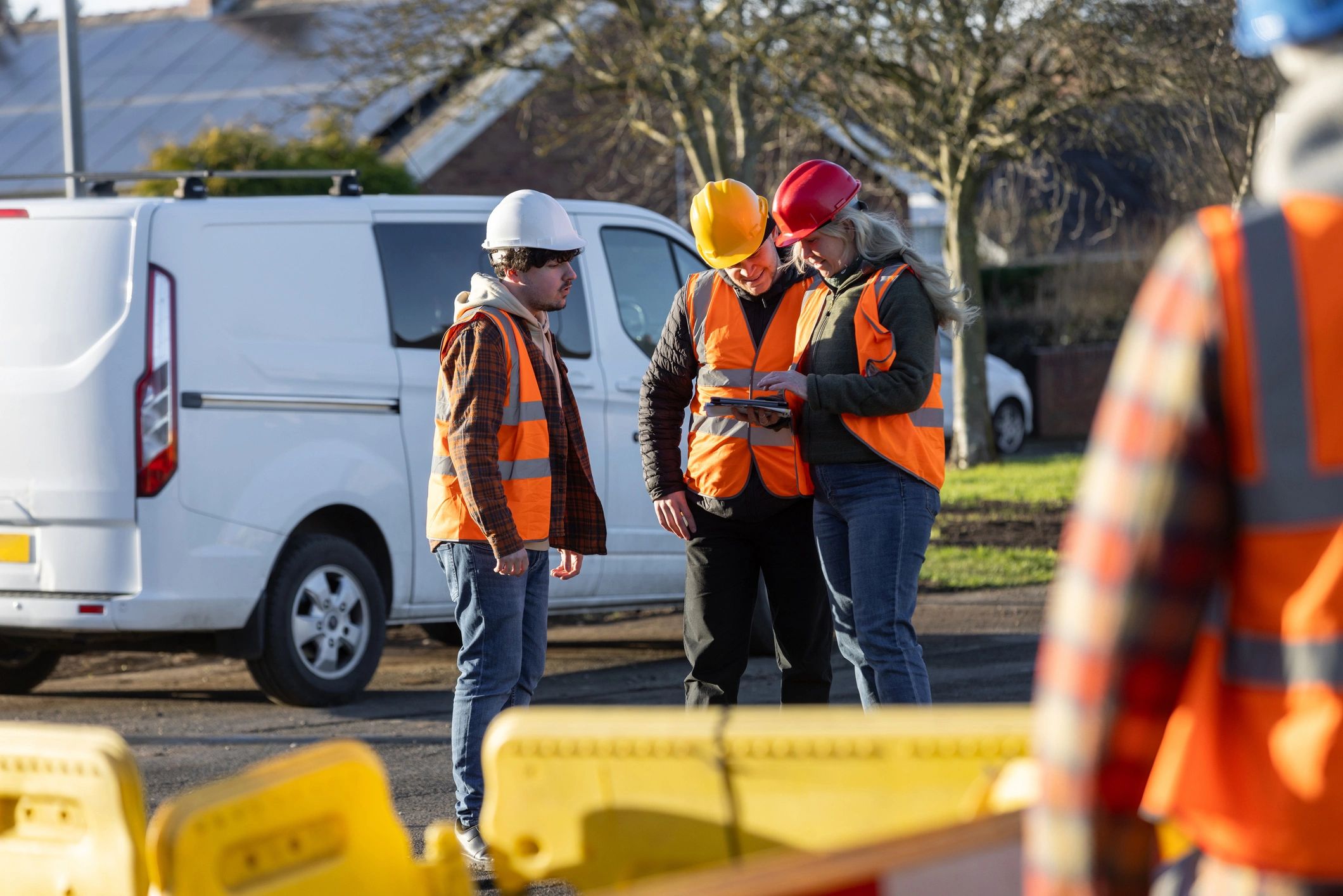 Team members in safety gear reviewing plans together